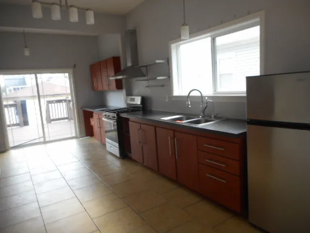 a kitchen with stainless steel appliances granite countertop a sink stove and a refrigerator