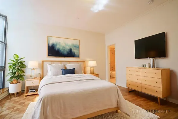 a bedroom with a bed and a flat screen tv