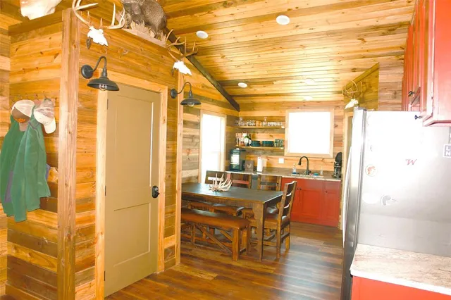 a dining room with stainless steel appliances a table and chairs