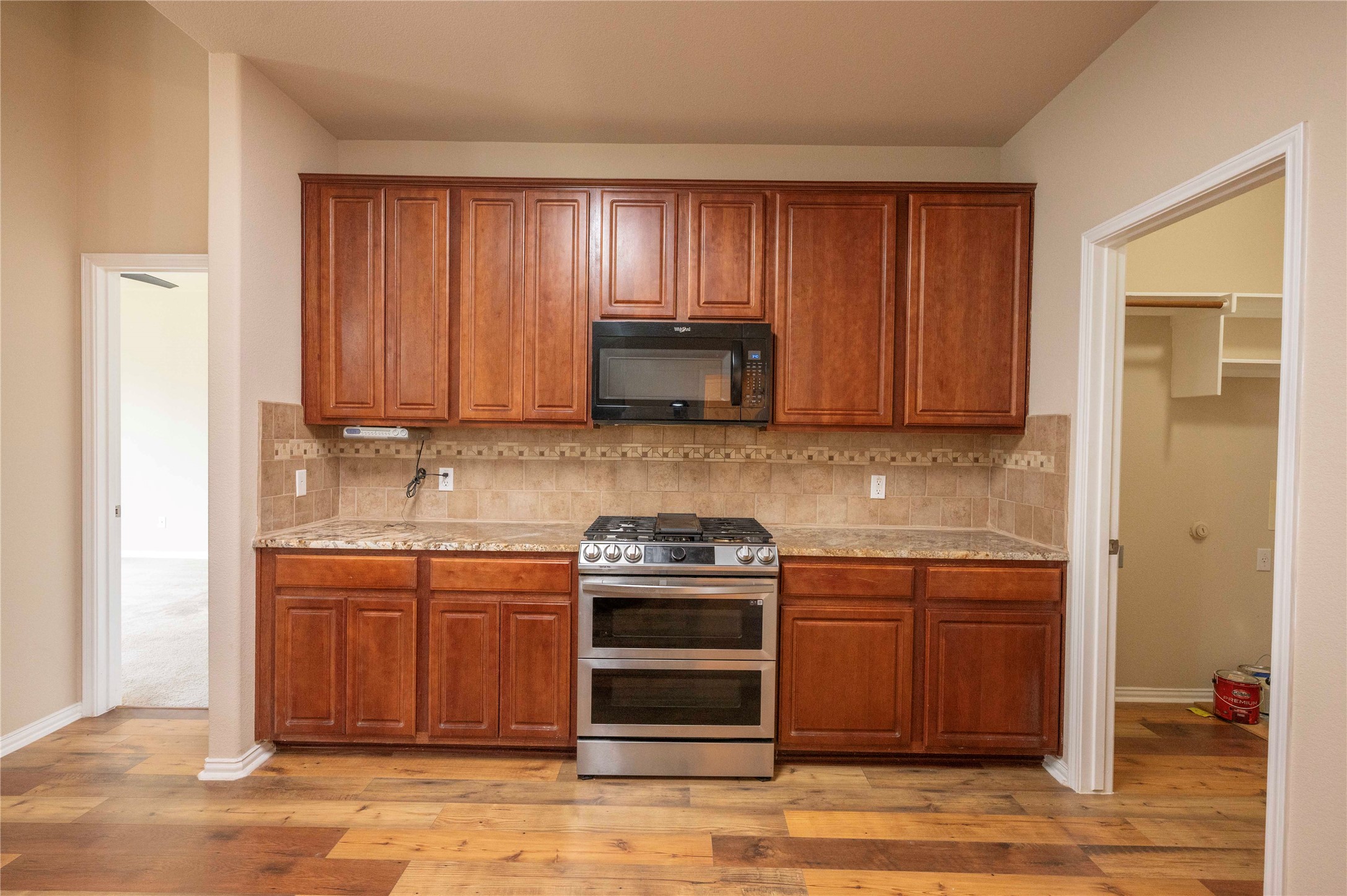 2070 Intrepid Drive Buda, TX 78610 - Photo 5 of 31 A well-appointed kitchen features rich wooden cabinetry, granite counters, and modern stainless steel appliances.
