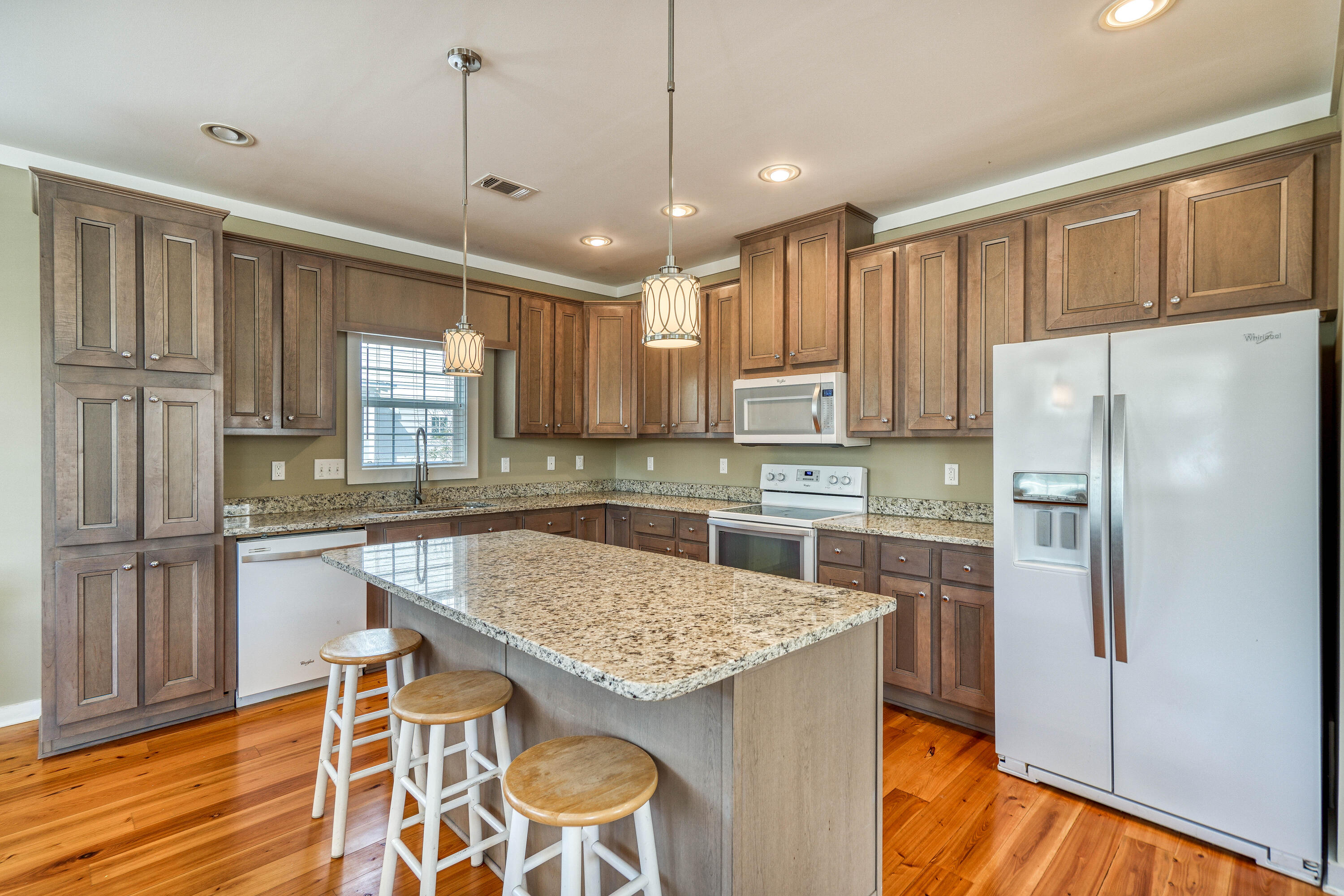 195 Maple Street Santa Rosa Beach, FL 32459 - Photo 7 of 29 a kitchen with stainless steel appliances granite countertop a refrigerator a sink dishwasher a stove and white countertops with wooden floor