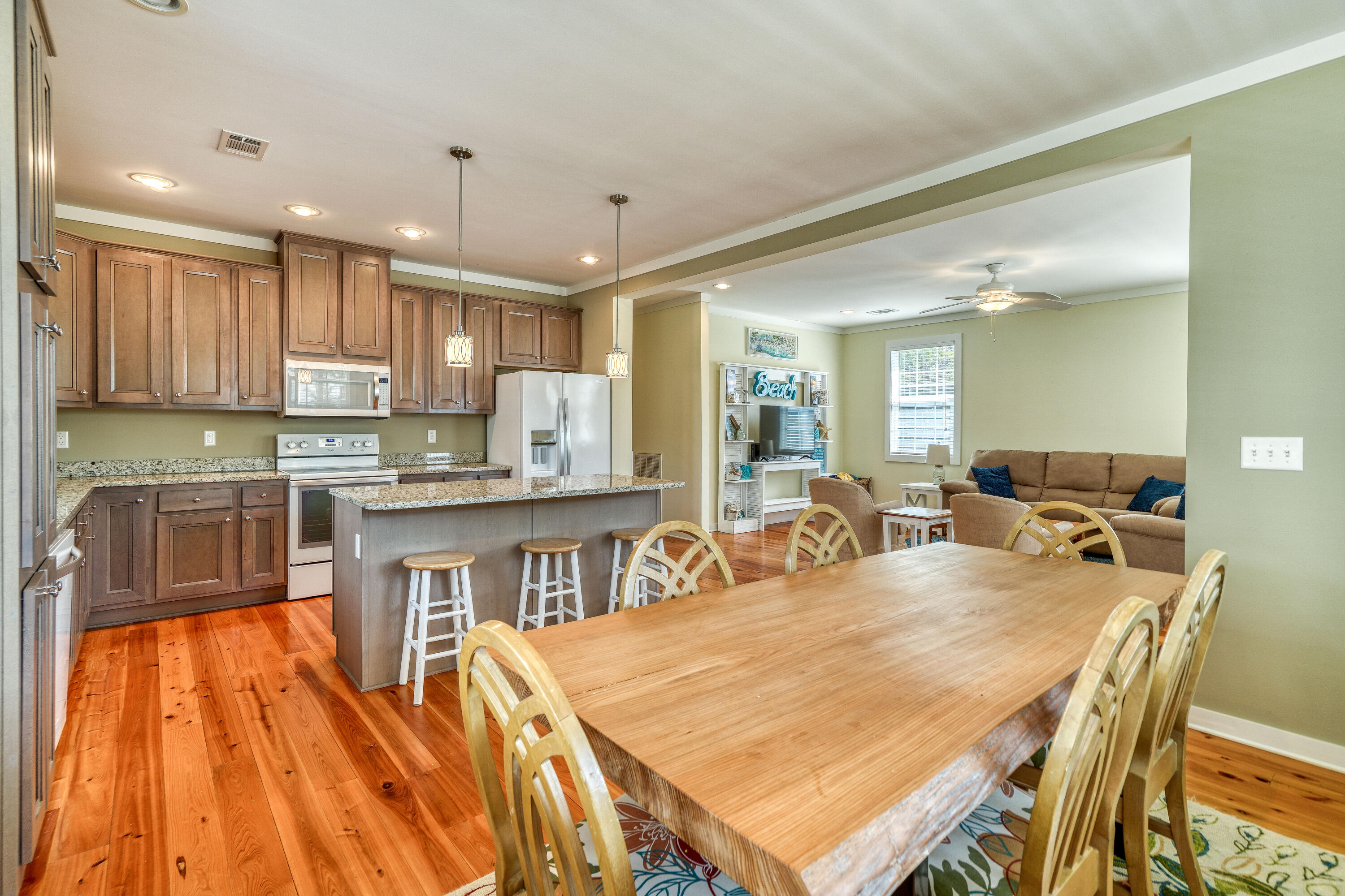 195 Maple Street Santa Rosa Beach, FL 32459 - Photo 8 of 29 a kitchen with stainless steel appliances granite countertop a stove top oven a sink dishwasher a dining table and chairs with wooden floor
