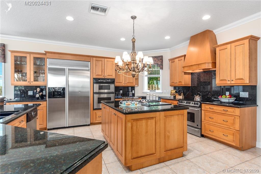 2021 Southeast Riverside Drive Stuart, FL 34996 - Photo 23 of 47 a kitchen with stainless steel appliances granite countertop a sink a stove and a refrigerator