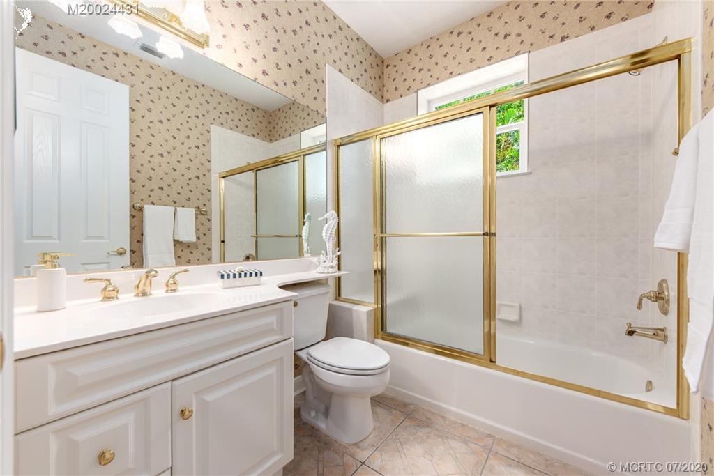 2021 Southeast Riverside Drive Stuart, FL 34996 - Photo 33 of 47 a bathroom with a double vanity sink toilet mirror and shower