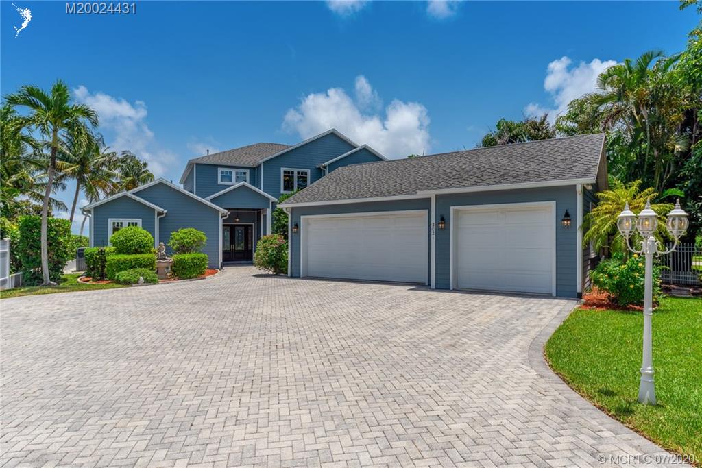 2021 Southeast Riverside Drive Stuart, FL 34996 - Photo 9 of 47 a front view of a house with a yard and garage