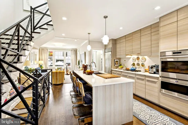 a kitchen with stainless steel appliances kitchen island granite countertop a stove a sink dishwasher and a refrigerator with wooden floor