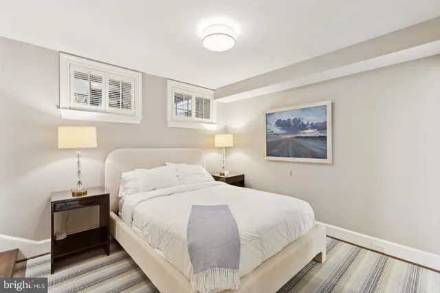 a bedroom with a bed and a lamp on dresser