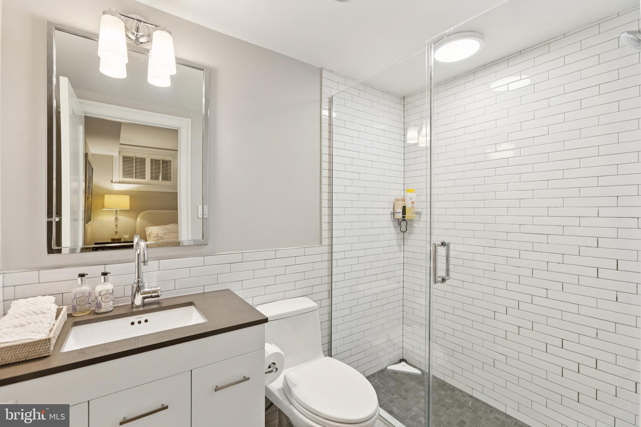 1724 34th Street Northwest Washington, DC 20007 - Photo 28 of 38 a bathroom with a granite countertop sink toilet a mirror and shower
