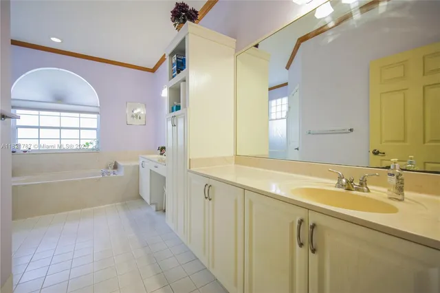 a bathroom with a tub sink and mirror