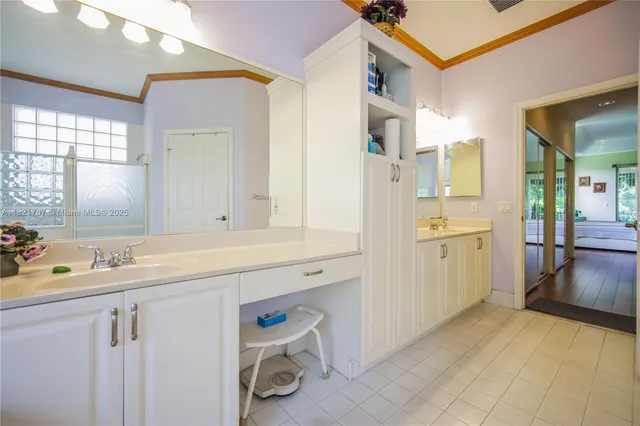 a view of a kitchen with a sink and dishwasher with white cabinets