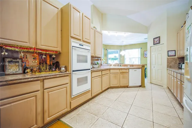 a kitchen with white cabinets and white appliances