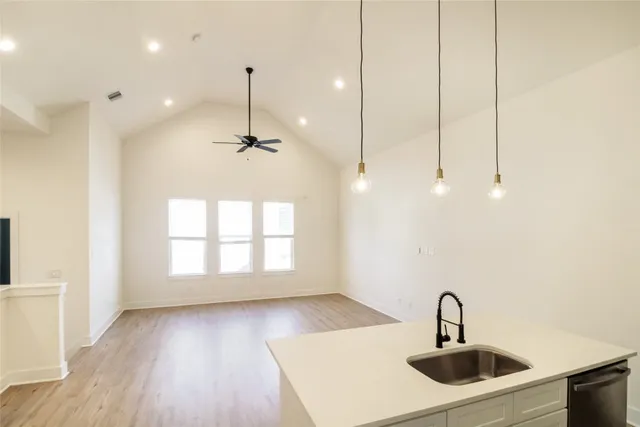 a kitchen with a sink a faucet and wooden floor