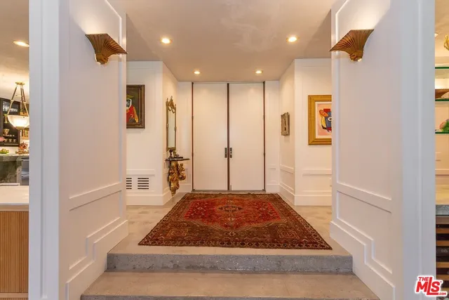 a view of a hallway with wooden floor and a cabinet