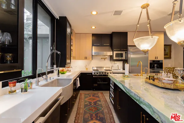 a large kitchen with kitchen island a large counter space a sink and appliances