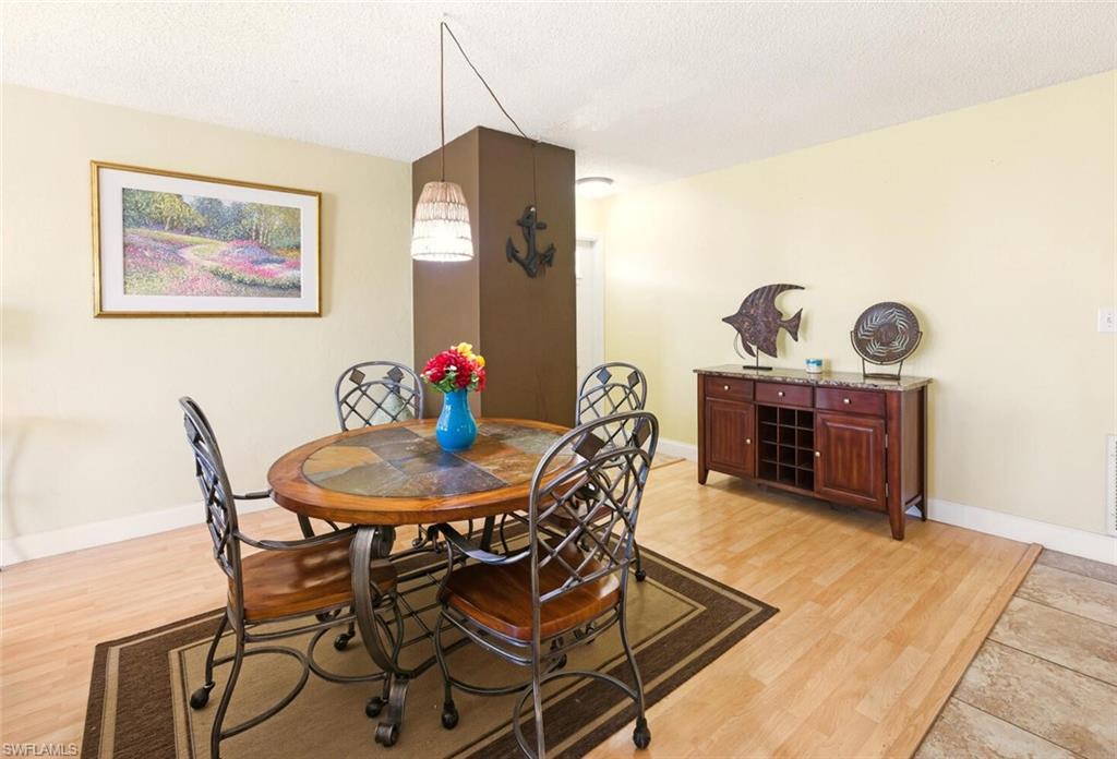 272 Palm Drive, Unit 2 Naples, FL 34112 - Photo 11 of 44 a view of a dining room with furniture and wooden floor
