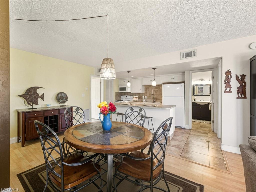 272 Palm Drive, Unit 2 Naples, FL 34112 - Photo 12 of 44 a view of a dining room with furniture and chandelier