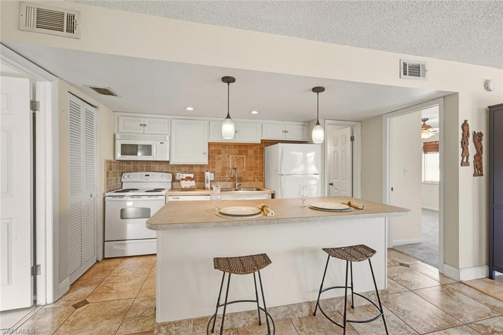272 Palm Drive, Unit 2 Naples, FL 34112 - Photo 13 of 44 a kitchen with stainless steel appliances kitchen island granite countertop a refrigerator and a stove top oven