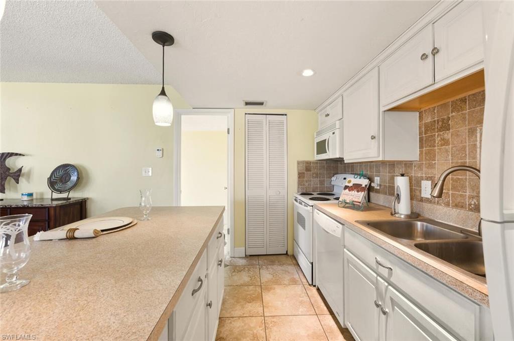 272 Palm Drive, Unit 2 Naples, FL 34112 - Photo 15 of 44 a kitchen with kitchen island granite countertop a sink stainless steel appliances and cabinets