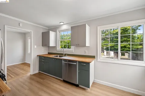 a kitchen with stainless steel appliances granite countertop a sink and a granite counter tops with a large window