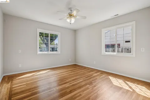 a view of empty room with window and ceiling fan