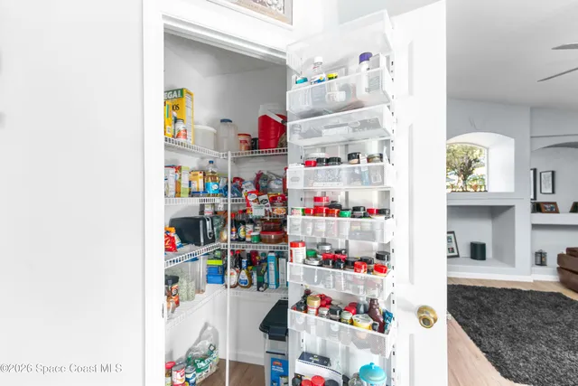a dining room with wooden floor a chandelier a wooden table and chairs