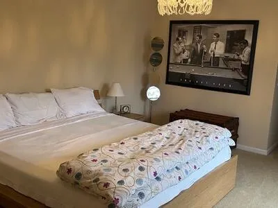 a bedroom with a bed and painting on the wall