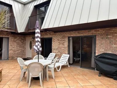 a patio with table and chairs and potted plants