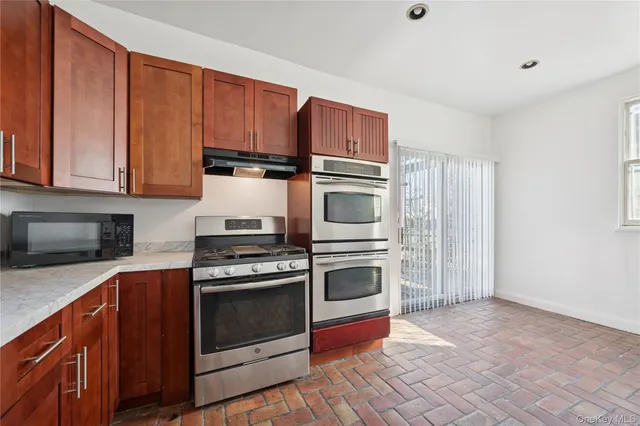 a kitchen with granite countertop wooden cabinets and stainless steel appliances