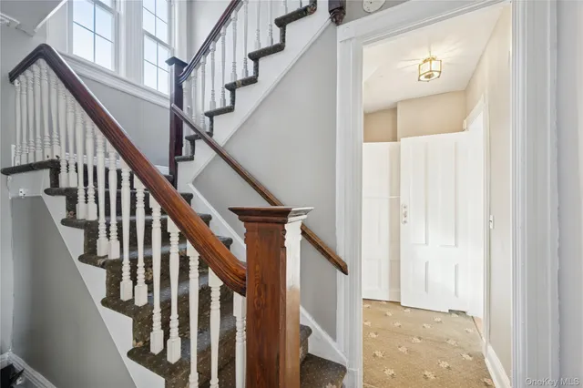 a view of staircase with wooden floor and white walls