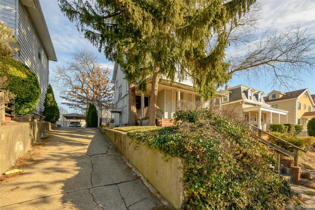 a front view of a multi story residential apartment building with yard and tree s