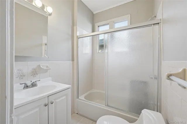 a bathroom with a bathtub shower sink vanity and toilet
