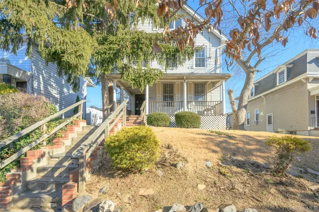 a front view of a house with a yard and potted plants