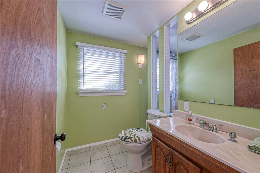 1816 Cardinal Avenue Aliquippa, PA 15001 - Photo 17 of 30 a bathroom with a granite countertop toilet a sink and a mirror