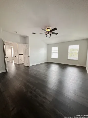 a view of empty room with wooden floor and window