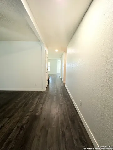 a view of a hallway with wooden floor