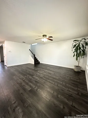 a view of an empty room with wooden floor