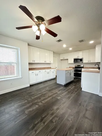 a large kitchen with stainless steel appliances granite countertop a stove and a sink