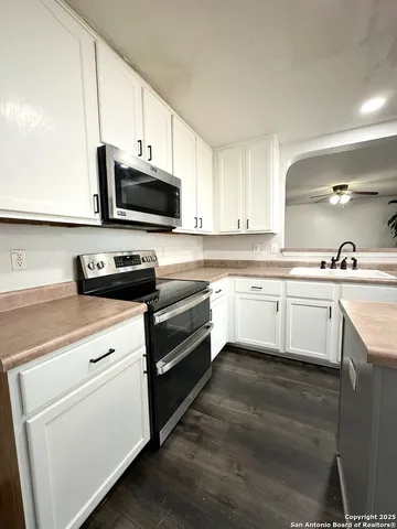 a kitchen with cabinets stainless steel appliances and a sink