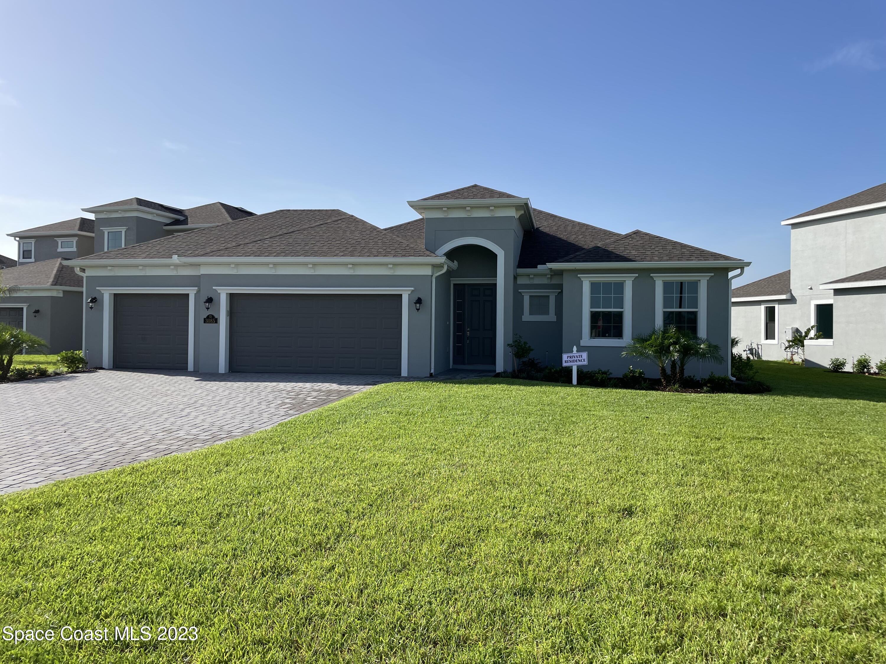 a front view of a house with a garden and yard