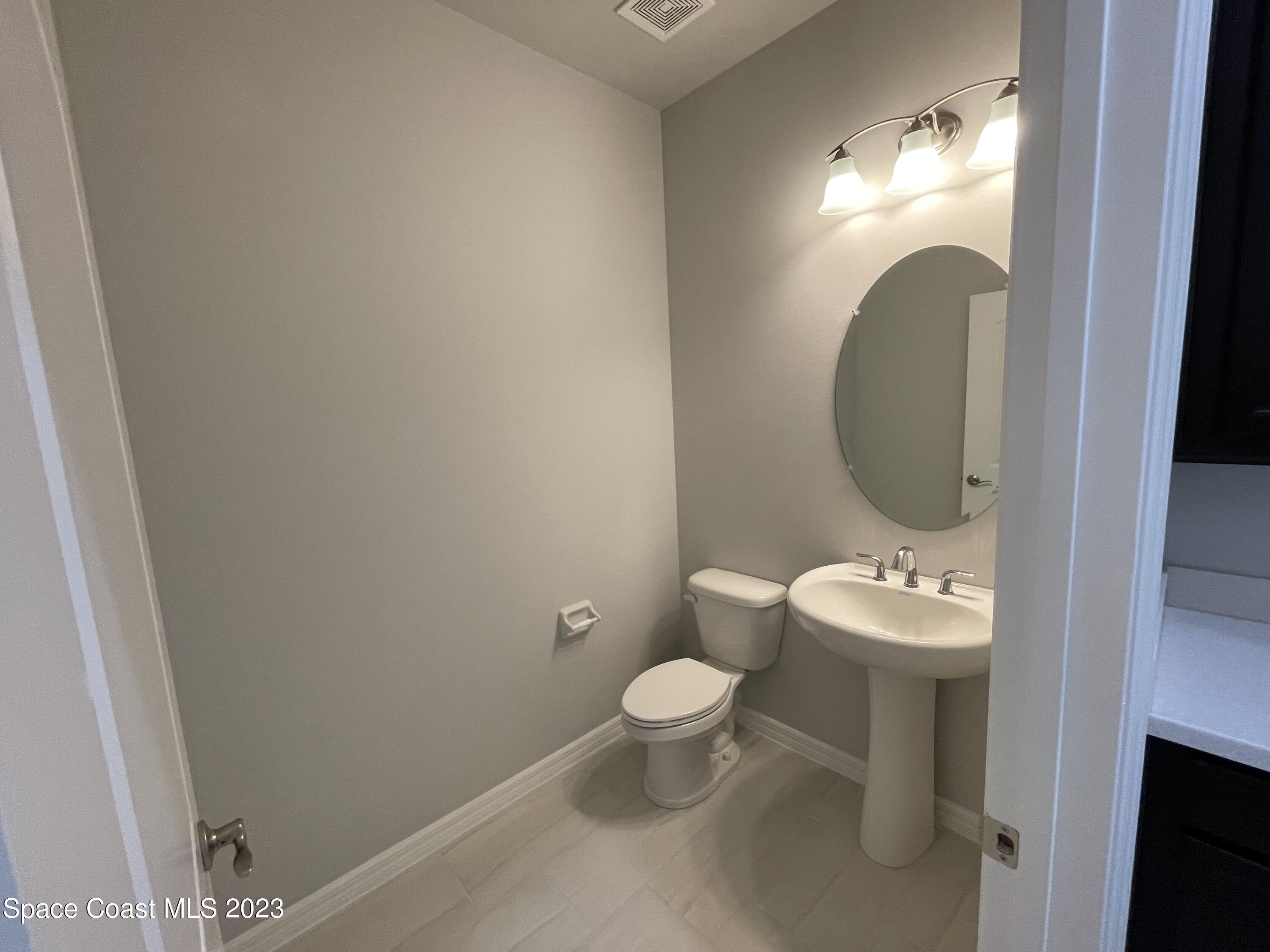 3085 Zeler Place Melbourne, FL 32940 - Photo 14 of 16 a bathroom with a toilet sink and mirror