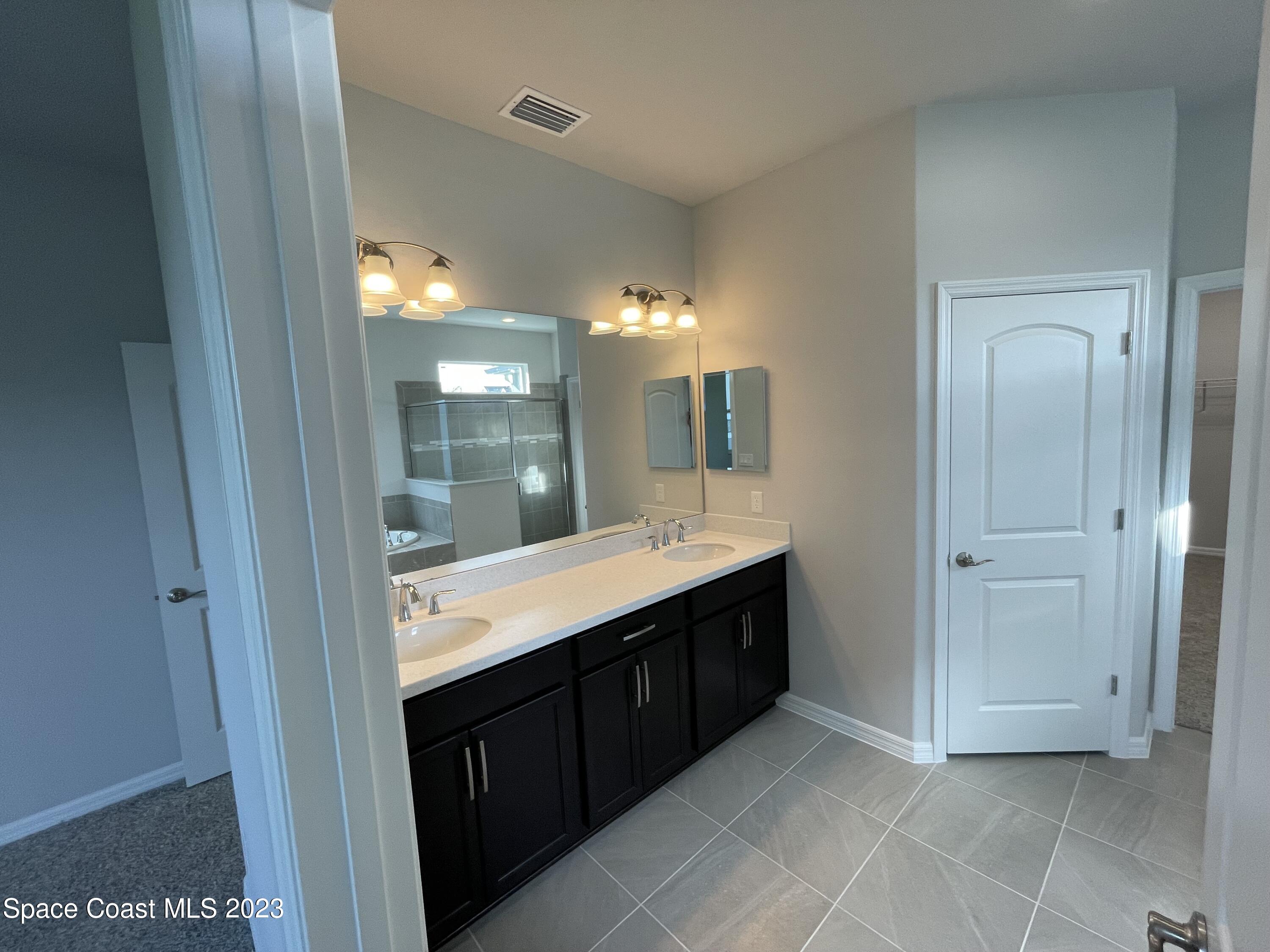 3085 Zeler Place Melbourne, FL 32940 - Photo 5 of 16 a bathroom with a sink and a mirror
