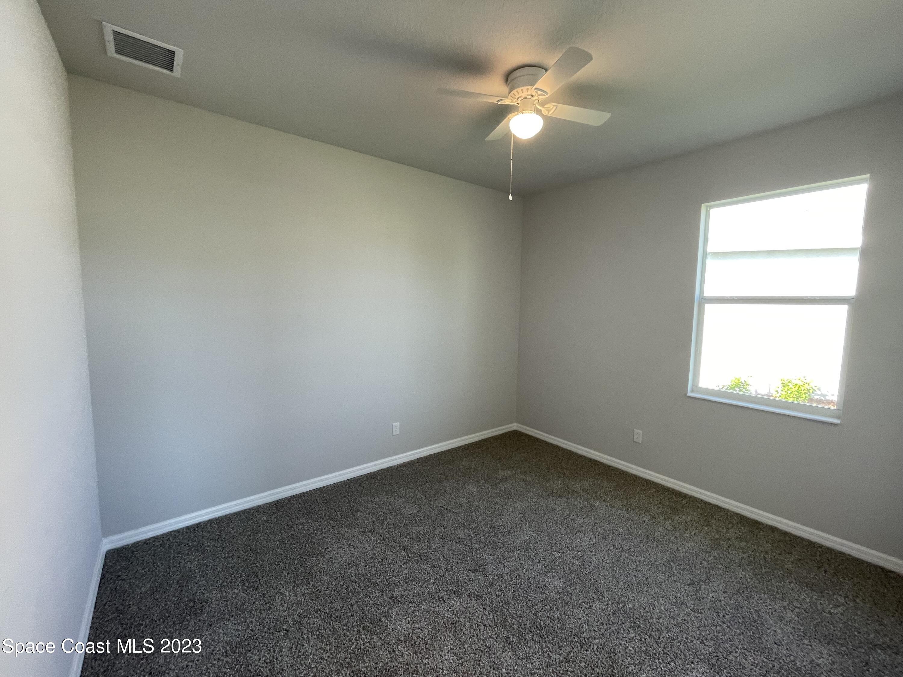 3085 Zeler Place Melbourne, FL 32940 - Photo 10 of 16 an empty room with a window and a fan