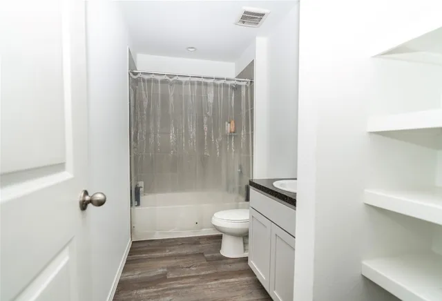 a bathroom with a shower a toilet and a sink