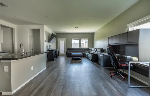 a living room with furniture and a wooden floor