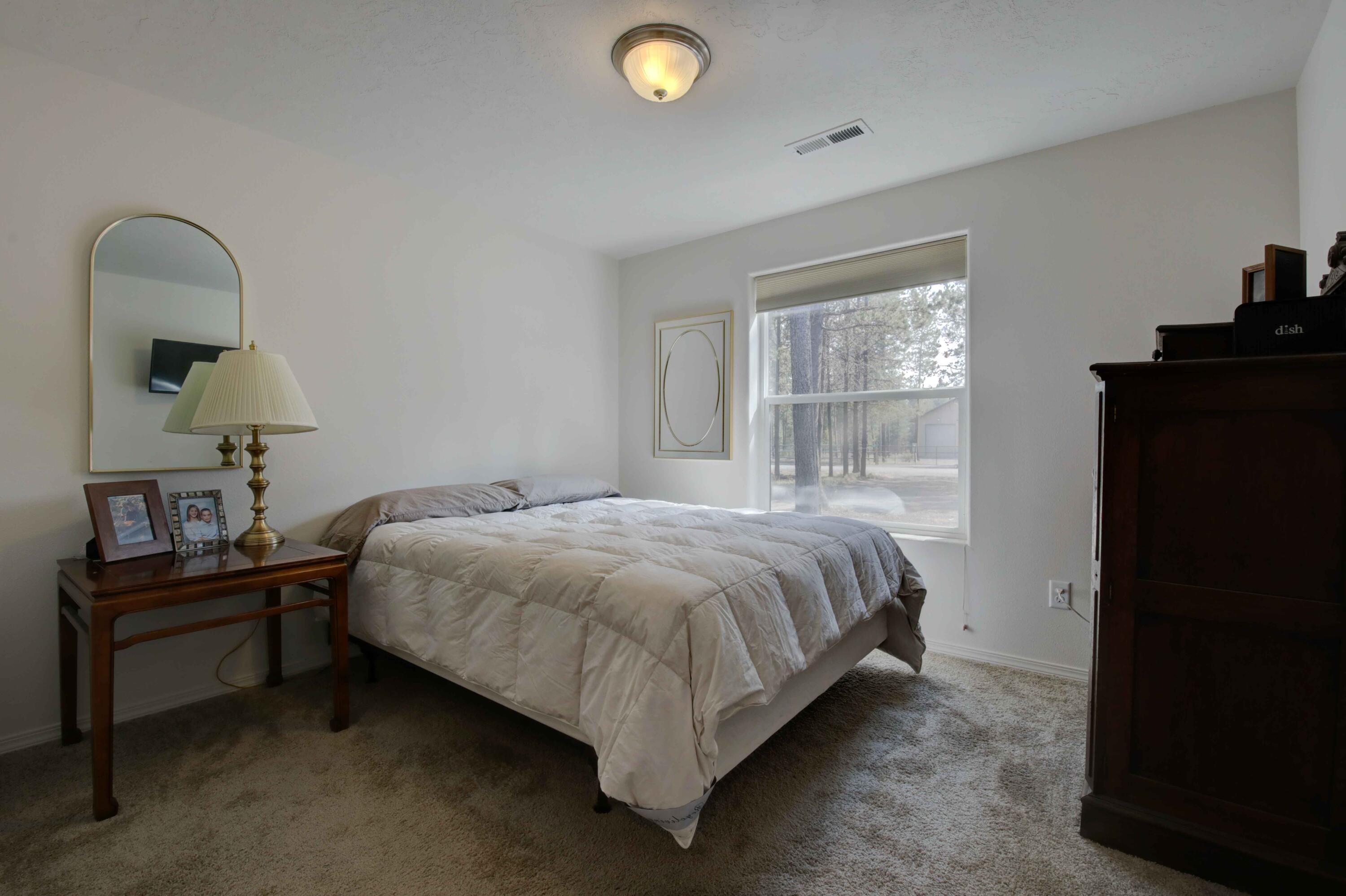 17160 Elsinore Road Bend, OR 97707 - Photo 23 of 47 a bed sitting in a bedroom next to a window