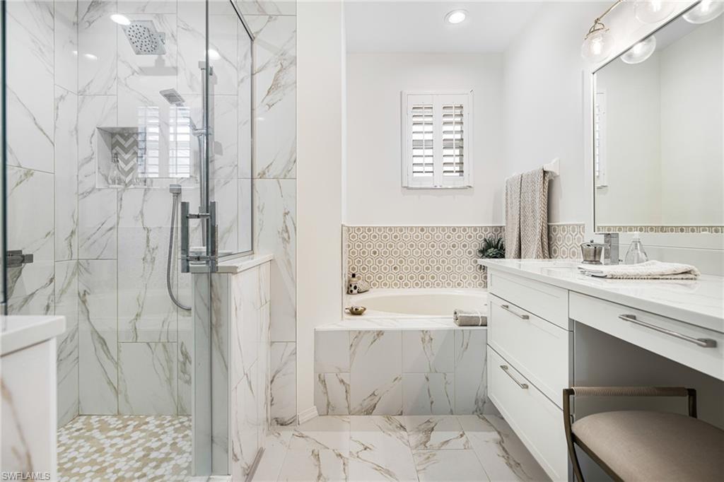 19071 Ridgepoint Drive, Unit 202 Estero, FL 33928 - Photo 18 of 26 a bathroom with a double vanity sink toilet mirror and bathtub