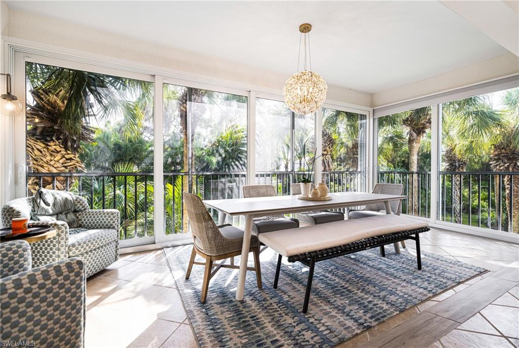 19071 Ridgepoint Drive, Unit 202 Estero, FL 33928 - Photo 6 of 26 a view of a dining room with furniture large windows and wooden floor