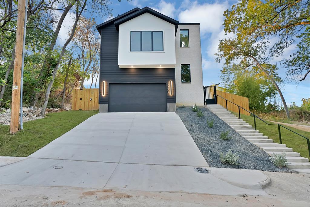 1415 Fayette Street Dallas, TX 75203 - Photo 7 of 40 Modern exterior featuring dark siding, white stucco accents, and a large concrete driveway