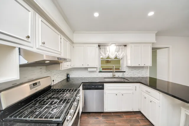 a kitchen with stainless steel appliances granite countertop a stove and a sink