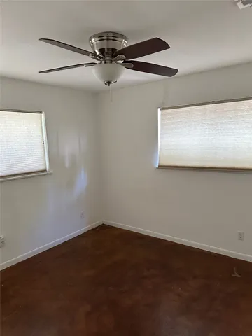 an empty room with a ceiling fan and a window